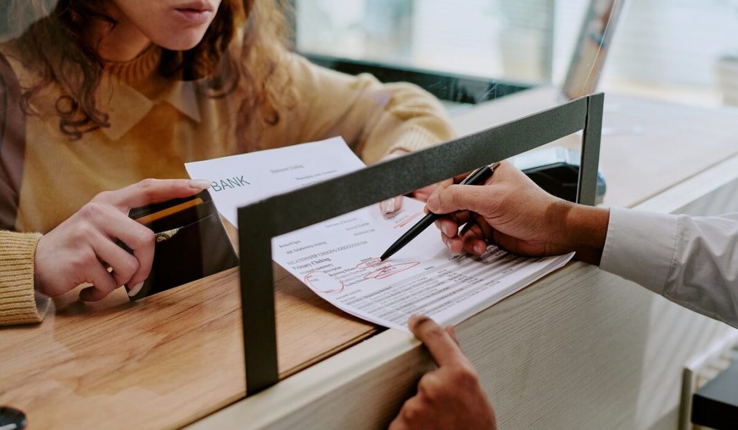 Detailed,View,Of,Person,Filling,Out,Forms,At,Bank,Counter,
