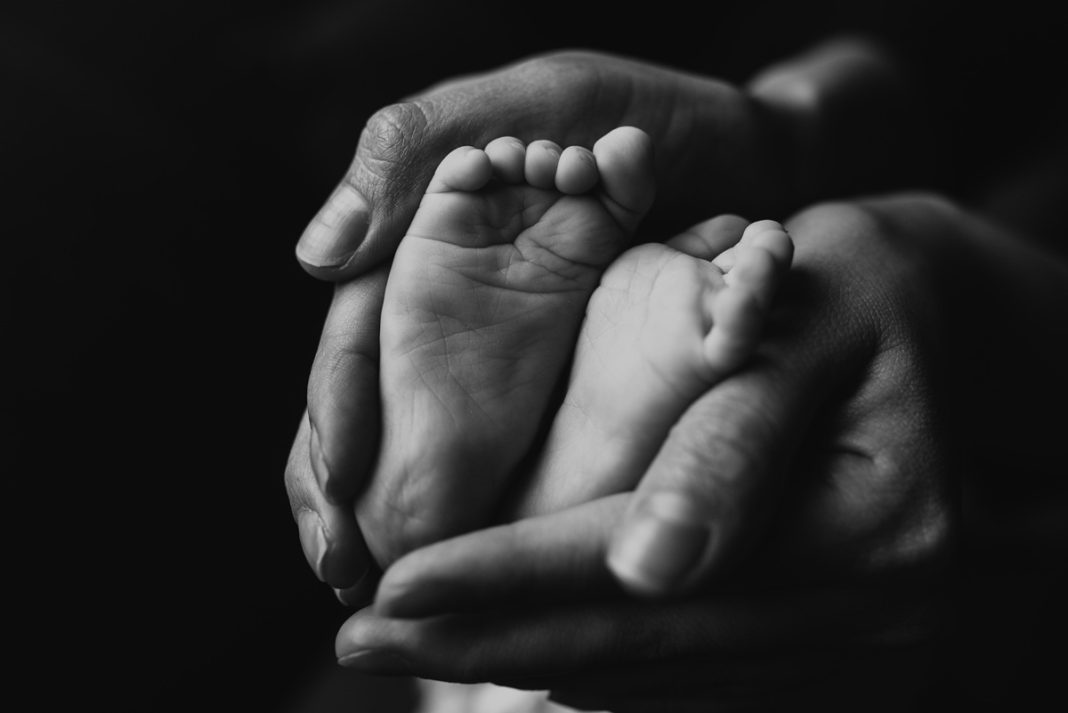 Breathtaking grayscale shot of the baby feet in mother hands